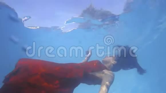 穿红色衣服的漂亮女人正在水下游泳摸着水面4K视频的预览图