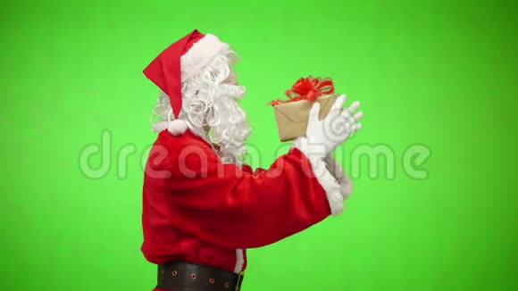 圣诞快乐穿着红色西装的圣诞老人在绿色屏幕背景色键上的盒子里送出礼物侧视视频的预览图
