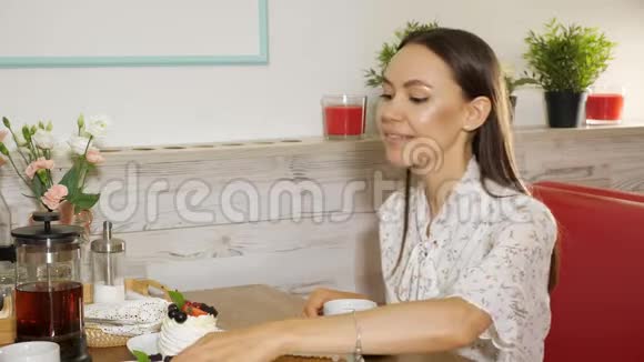 快乐的女孩吃美味的蛋糕和浆果现代甜店视频的预览图