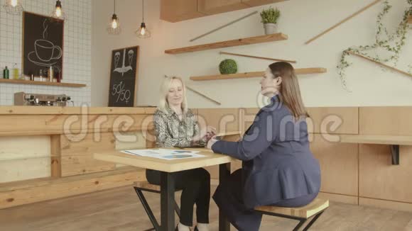 两位女商务同事在咖啡厅点餐视频的预览图