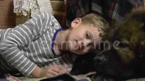 男孩躺在女主人脚下的狗旁边视频的预览图