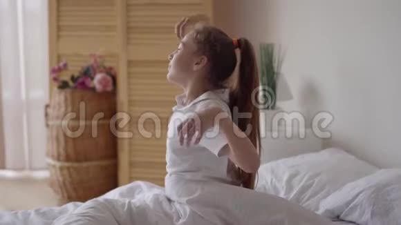 白种人儿童可爱的放松或儿童女孩醒来后伸展自己在早上清爽视频的预览图