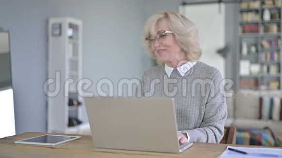 在现代办公室做电脑视频聊天的老女人视频的预览图