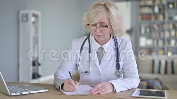 老年女性医生做文书工作视频的预览图