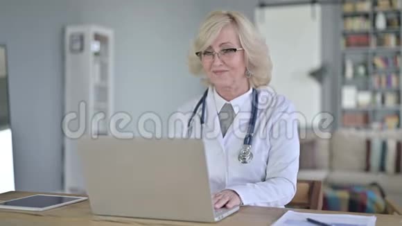 老女医生正在进行电脑视频聊天视频的预览图