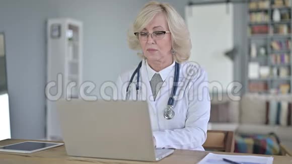 使用手提电脑的老女医生视频的预览图