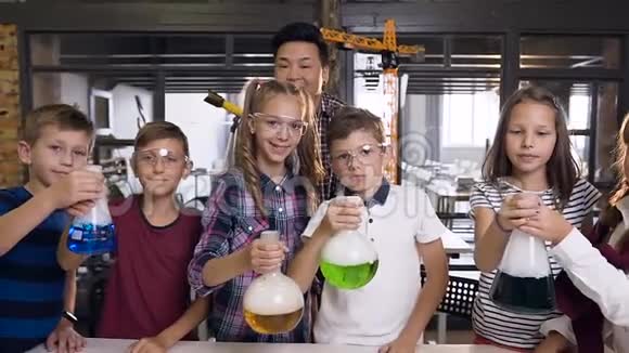 韩国男教师与六组性格开朗的年轻白种人学生在化学过程中戴护目镜的肖像拍摄视频的预览图