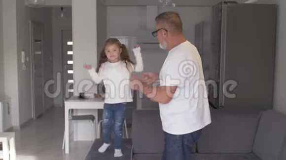 快乐的祖父和他的孙女在家跳舞高级生活方式家庭观念视频的预览图