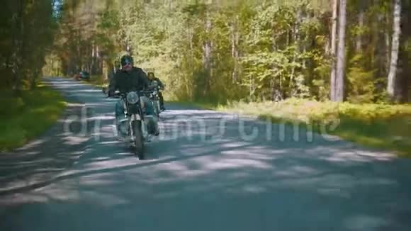 两个戴着头盔的野蛮摩托车手在针叶林骑摩托车视频的预览图