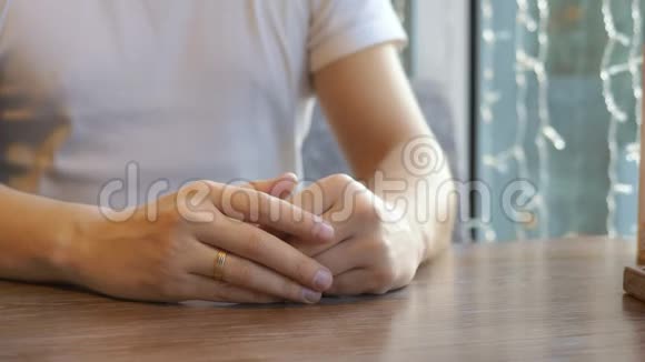 特写镜头那个人戴着结婚戒指坐在咖啡馆里视频的预览图