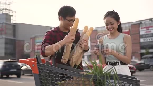 30多岁的越南男人戴着眼镜拿着夹心滚筒他可爱的女朋友在大商店附近数钱视频的预览图