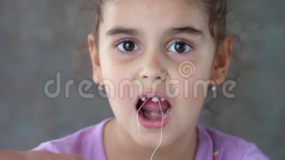大人的手把绑在孩子牙齿上线拉移除牙齿的尝试失败拔出牙齿视频的预览图