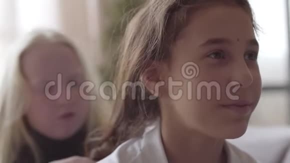 可爱的白化病小女孩编织她的黑发女朋友的长发友谊的概念免费儿童视频的预览图