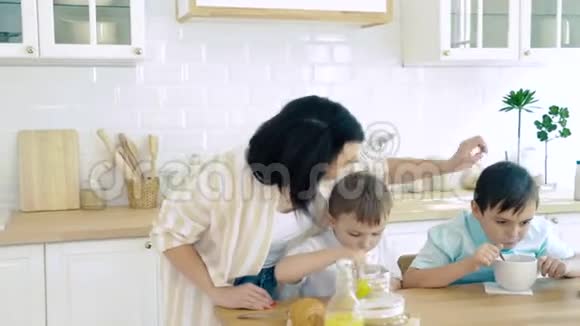 快乐的妈妈照顾她的儿子当他们吃饭视频的预览图