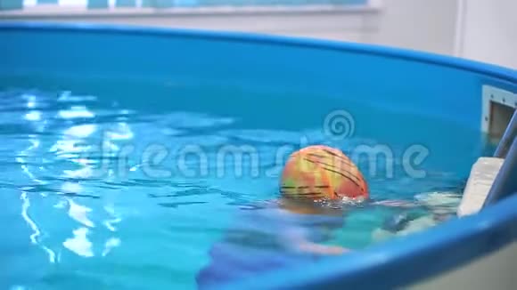 游泳池里的一个小男孩潜入水中他在学习视频的预览图