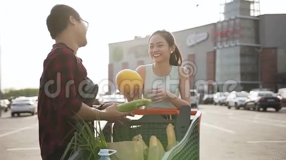 漂亮的微笑亚洲夫妇满足了他们选择的甜瓜和市场上的另一种食物视频的预览图