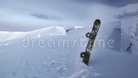雪板站在雪地里在一个山脉的背景下陷在雪堆里白雪覆盖的冬天视频的预览图
