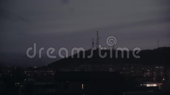 黄昏时分小镇附近山上的电视天线视频的预览图