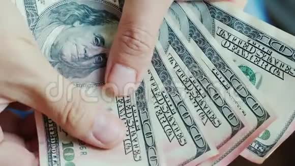 男人手指看着美元钞票金钱被粉红色的油漆损坏了视频的预览图