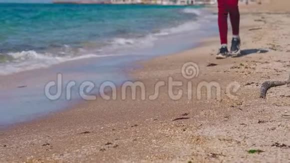 一个穿着运动鞋的少年在海边的台阶视频的预览图