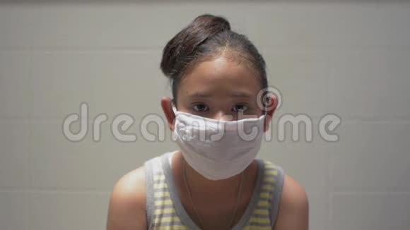 肖像亚洲可爱女孩在家中脱下防护面罩和饮用水视频的预览图