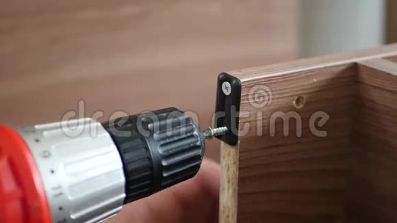 一个人用螺丝和电钻把一个钢件拧成木制品木匠师傅把这些视频的预览图