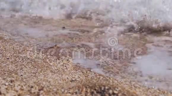 海浪冲刷沙滩特写中的脚印视频的预览图
