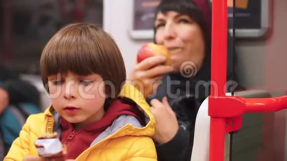 孩子和妈妈在地铁火车上吃东西视频的预览图