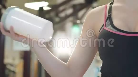漂亮的女孩在健身房喝了一杯蛋白奶昔饮料微笑着视频的预览图