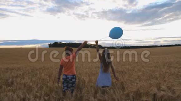小女孩和男孩站在麦田里从手中释放气球进入天空可爱的小孩玩得开心视频的预览图