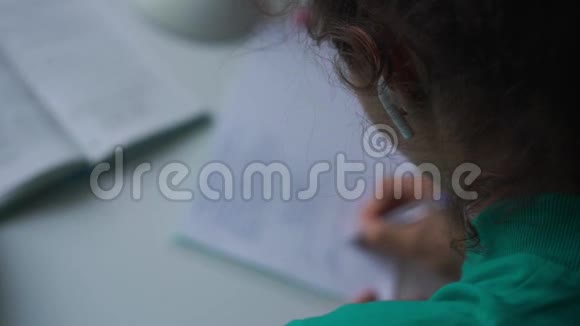 用无线耳机听音乐的女孩做家庭作业视频的预览图