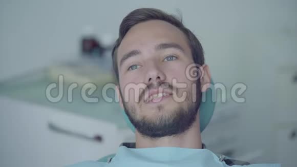 牙科医生办公室里一个年轻害怕的男人用手捂住嘴巴的特写照片医生和护士的手视频的预览图