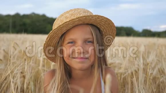 戴着草帽的漂亮小女孩的肖像看着镜头笑着用手捂住脸小快乐视频的预览图