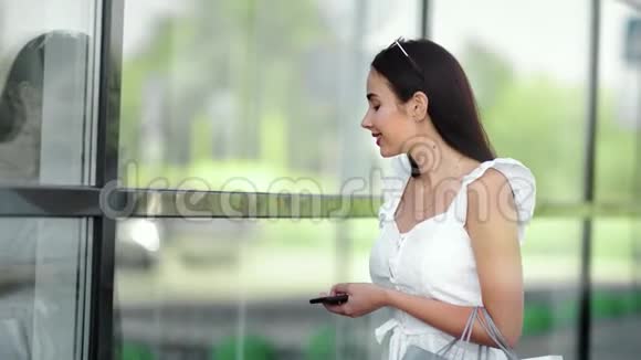 微笑时尚的年轻女性看着橱窗展示的时髦服装店视频的预览图