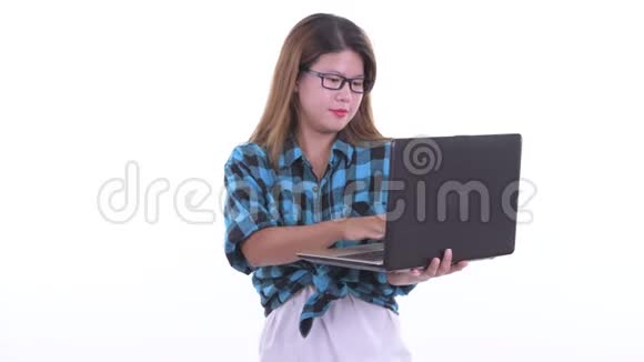 快乐的年轻亚洲时髦女人在用笔记本电脑说话视频的预览图