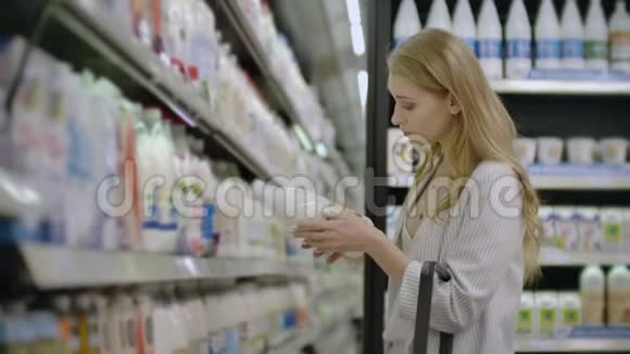 广告商业食品健康概念在超市里站在冰箱前的女人选择购买视频的预览图