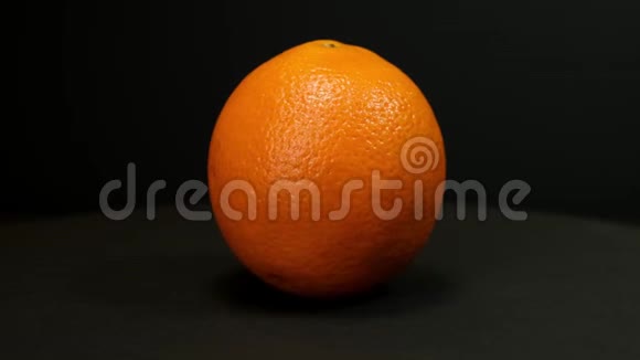 橙色水果在黑色背景上旋转关门视频的预览图