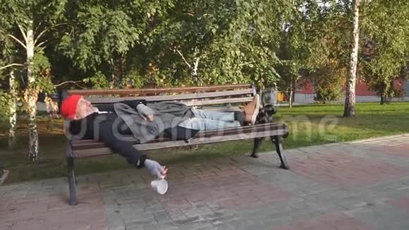 无家可归的人白天睡在公园的长凳上视频的预览图