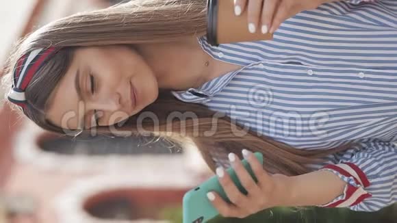 圣经录像带着时髦条纹衬衫头巾的年轻女士使用她的智能手机语音指挥官或视频的预览图