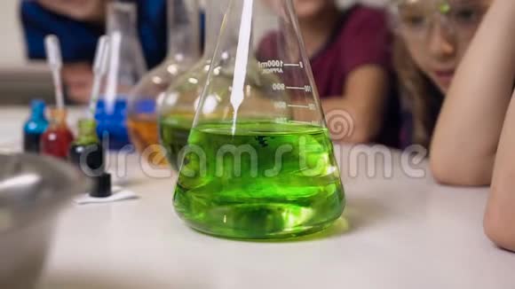 关上门实验室工作人员在玻璃瓶中将化学液体与水混合向孩子们展示化学反应是如何进行的视频的预览图
