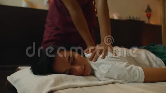 一位高加索女人在水疗中心做泰式按摩放松身心传统死亡的亚洲女性背部按摩视频的预览图