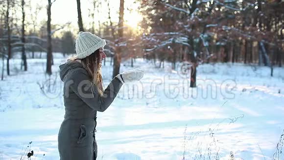 在冬天的森林里吹雪女人在户外玩得很开心季节性活动女孩笑着穿暖衣服视频的预览图