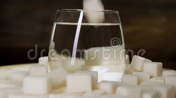 糖片和水玻璃在黑色背景上旋转快关门视频的预览图