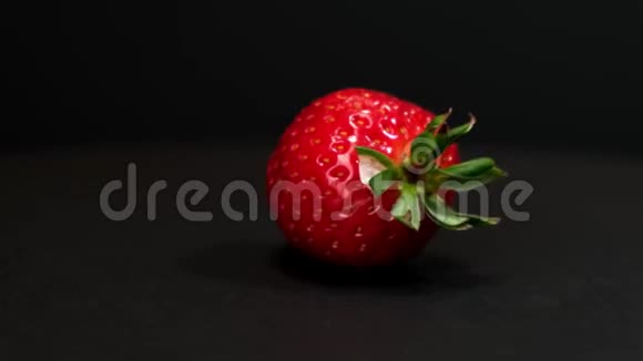 新鲜草莓在黑色背景上旋转快关门视频的预览图