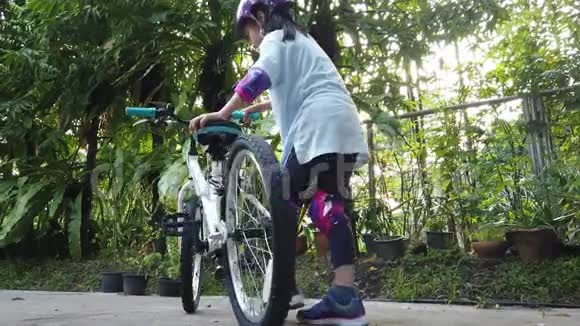小女孩学习并开始骑自行车与全保护装备视频的预览图