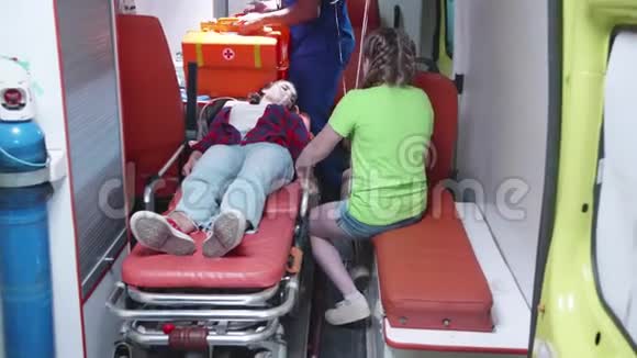 受伤的妇女躺在救护车上视频的预览图