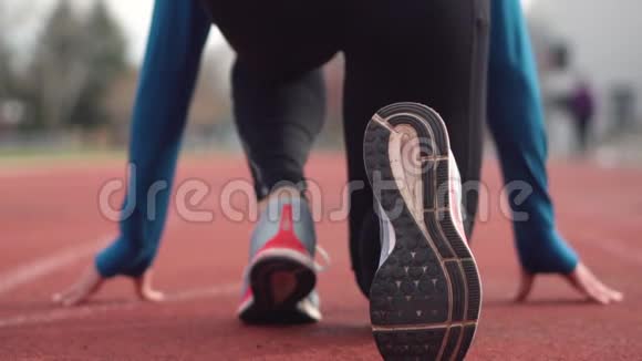 一位年轻运动员在跑道上为比赛做准备的背景视频的预览图