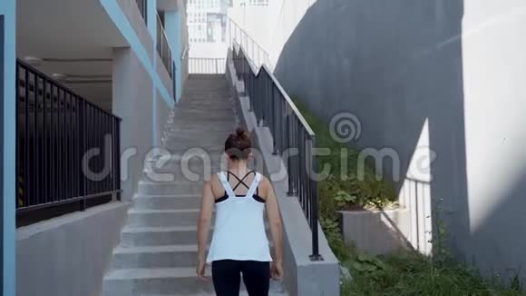在楼梯上跑女人在楼梯上跑女运动员爬楼梯运动锻炼跑外视频的预览图