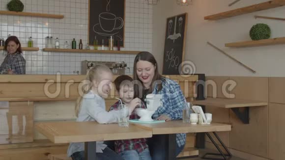 快乐的孩子和妈妈在咖啡馆玩有趣的玩具视频的预览图