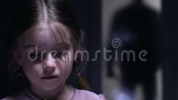 可爱的小女孩哭着害怕残忍的父亲在背后靠近视频的预览图